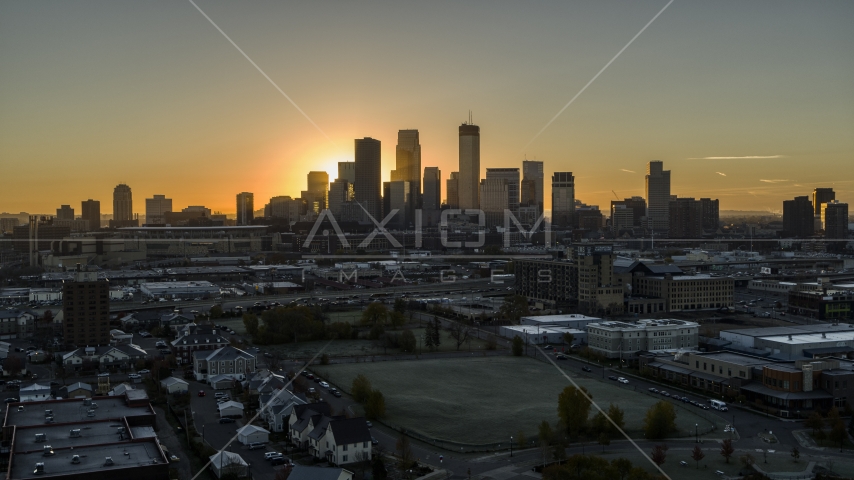 The bright sun behind tall skyscrapers in the city's skyline at sunrise in Downtown Minneapolis, Minnesota Aerial Stock Photo DXP001_000258 | Axiom Images