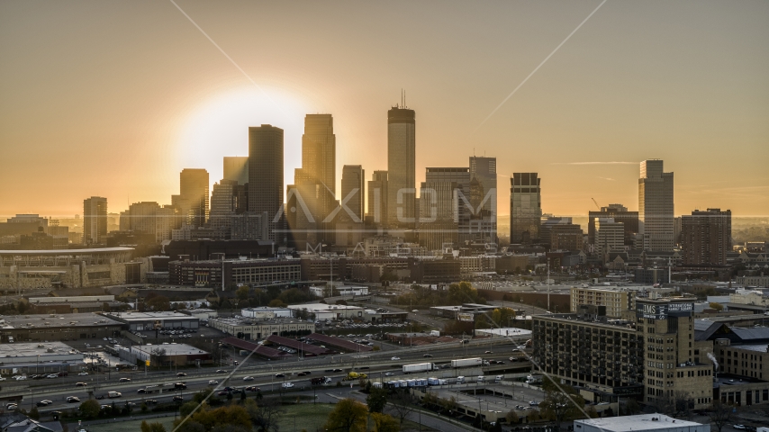 The glow of the sun rising beyond towering skyscrapers in the city's skyline in Downtown Minneapolis, Minnesota Aerial Stock Photo DXP001_000264 | Axiom Images