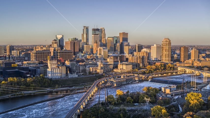 The city's skyline seen from the Stone Arch Bridge spanning the river at sunrise, Downtown Minneapolis, Minnesota Aerial Stock Photo DXP001_000355 | Axiom Images