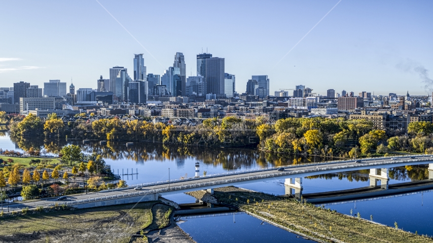 The city's skyline seen from a bridge spanning the tree-lined river, Downtown Minneapolis, Minnesota Aerial Stock Photo DXP001_000363 | Axiom Images