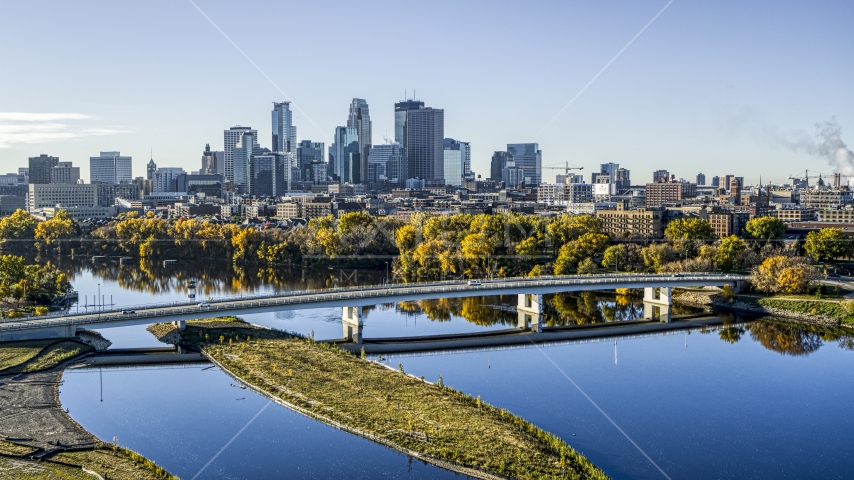 The city's skyline in the distance, seen from a bridge spanning the tree-lined river, Downtown Minneapolis, Minnesota Aerial Stock Photo DXP001_000364 | Axiom Images