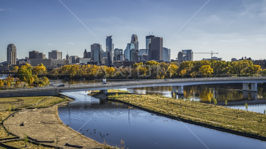 City skyline's skyscrapers seen from a bridge crossing the Mississippi River with fall trees, Downtown Minneapolis, Minnesota Aerial Stock Photo DXP001_000398 | Axiom Images