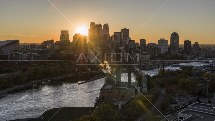 The sun setting behind the skyline across the Mississippi River, seen from riverfront power plant, Downtown Minneapolis, Minnesota Aerial Stock Photo DXP001_000424 | Axiom Images