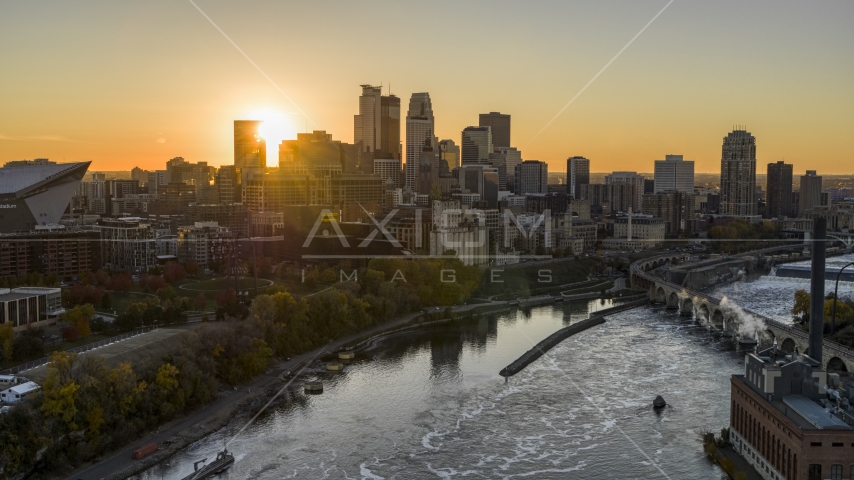 The sun setting behind the city skyline, seen from over the Mississippi River, Downtown Minneapolis, Minnesota Aerial Stock Photo DXP001_000425 | Axiom Images