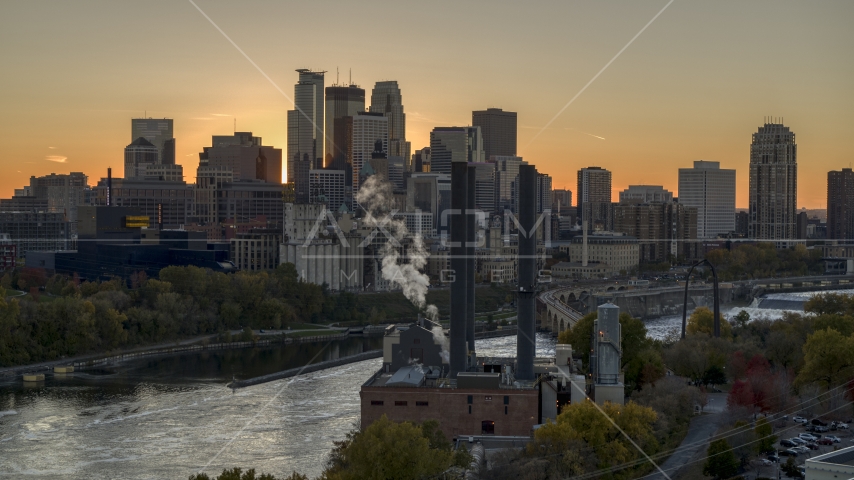 Power plant in foreground and city skyline on the other side of the river at sunset, Downtown Minneapolis, Minnesota Aerial Stock Photo DXP001_000431 | Axiom Images