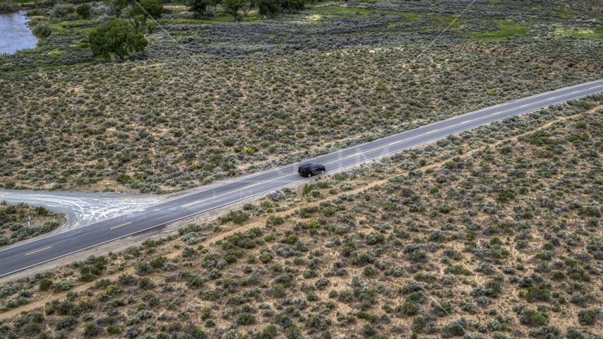 A black SUV parked on a desert road in Carson City, Nevada Aerial Stock Photo DXP001_007_0002 | Axiom Images