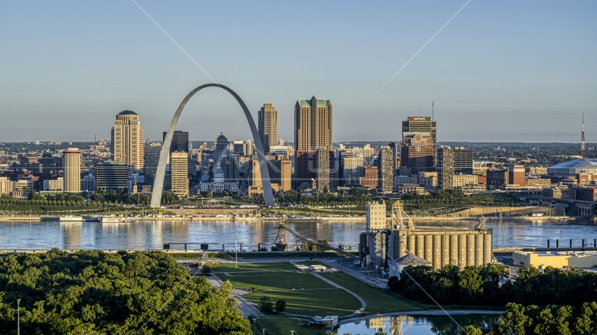 A grain elevator and park with a view of the Arch and skyline across the Mississippi River, sunrise, Downtown St. Louis, Missouri Aerial Stock Photo DXP001_021_0006 | Axiom Images