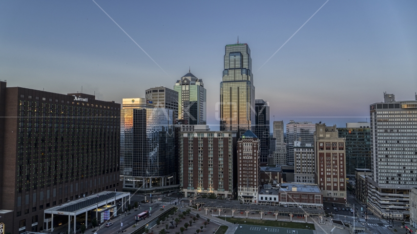 A downtown hotel beside tall city skyscrapers at twilight in Downtown Kansas City, Missouri Aerial Stock Photo DXP001_051_0018 | Axiom Images