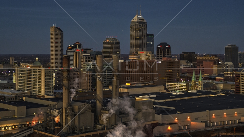 Smoke stacks and a view of city skyline at twilight in Downtown Indianapolis, Indiana Aerial Stock Photo DXP001_093_0001 | Axiom Images