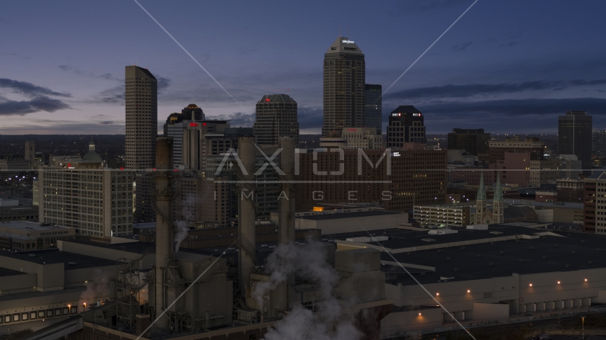 Smoke stacks and a view of city skyline at twilight in Downtown Indianapolis, Indiana Aerial Stock Photo DXP001_093_001 | Axiom Images