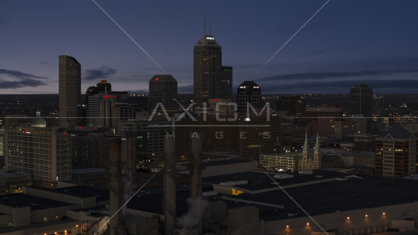 Giant skyscrapers of the city skyline at twilight, seen from smoke stacks, Downtown Indianapolis, Indiana Aerial Stock Photo DXP001_093_005 | Axiom Images
