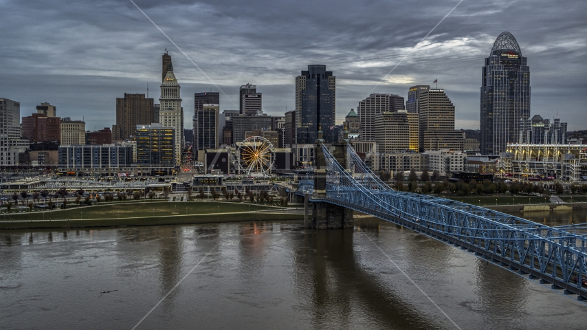 A view across the Ohio River near a bridge toward the city skyline at sunset, Downtown Cincinnati, Ohio Aerial Stock Photo DXP001_097_0009 | Axiom Images