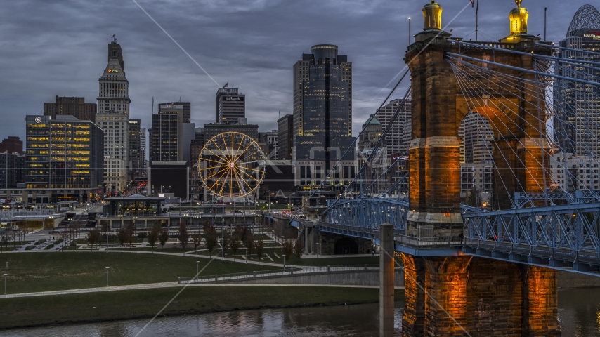 The Roebling Bridge near the Ferris wheel and city skyline at sunset, Downtown Cincinnati, Ohio Aerial Stock Photo DXP001_097_0014 | Axiom Images