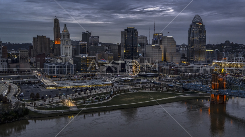 The city skyline and bridge lit at sunset, seen from Ohio River, Downtown Cincinnati, Ohio Aerial Stock Photo DXP001_097_0015 | Axiom Images