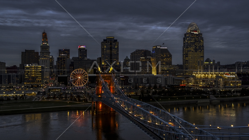 The Roebling Bridge lit up at twilight by the city skyline, Downtown Cincinnati, Ohio Aerial Stock Photo DXP001_098_0004 | Axiom Images