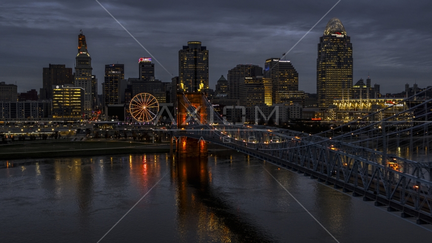 The lights of city skyline and bridge at twilight seen from the river, Downtown Cincinnati, Ohio Aerial Stock Photo DXP001_098_0007 | Axiom Images
