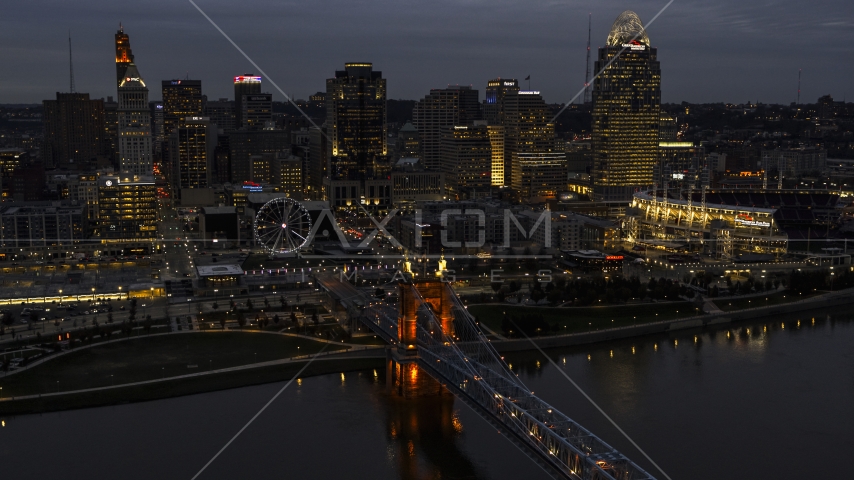 A view of the lights of city skyline and bridge at twilight, seen from river, Downtown Cincinnati, Ohio Aerial Stock Photo DXP001_098_0009 | Axiom Images