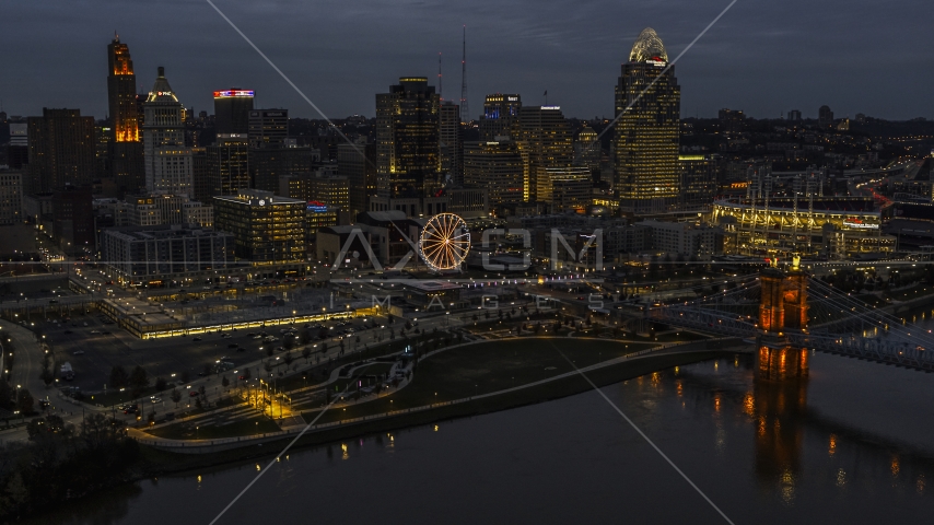 The lights of city's downtown skyline and bridge at twilight, seen from the river, Downtown Cincinnati, Ohio Aerial Stock Photo DXP001_098_0010 | Axiom Images