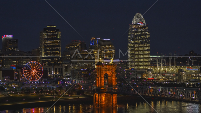The bridge, tall skyscrapers and Ferris wheel at night in Downtown Cincinnati, Ohio Aerial Stock Photo DXP001_098_0019 | Axiom Images