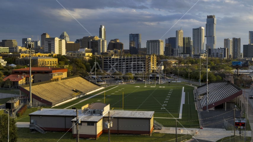 A view of skyscrapers from a football field at sunset in Downtown Austin, Texas Aerial Stock Photo DXP002_105_0003 | Axiom Images