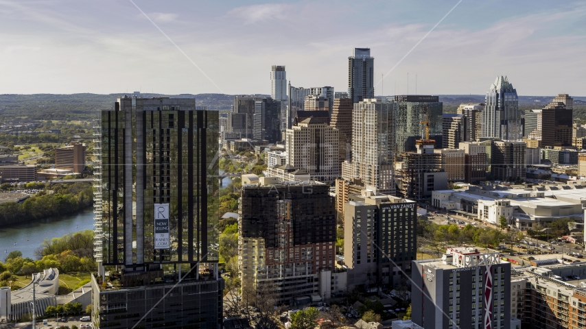 The city's skyline behind a high-rise near Lady Bird Lake in Downtown Austin, Texas Aerial Stock Photo DXP002_108_0015 | Axiom Images