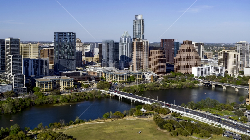 The city's skyline on the other side of Lady Bird Lake, seen from park by bridge, Downtown Austin, Texas Aerial Stock Photo DXP002_109_0004 | Axiom Images
