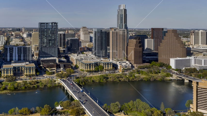 A view of skyscrapers of the city's skyline across Lady Bird Lake seen from a bridge, Downtown Austin, Texas Aerial Stock Photo DXP002_109_0007 | Axiom Images
