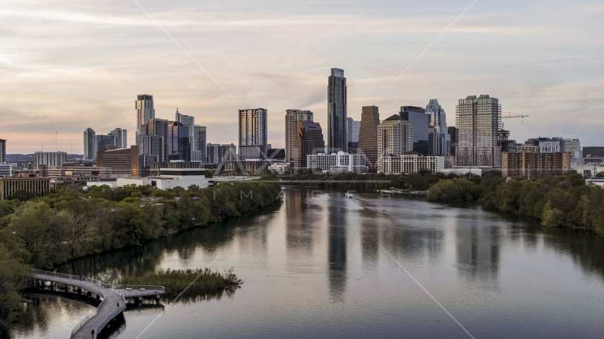 The city's skyline seen from low over Lady Bird Lake at sunset in Downtown Austin, Texas Aerial Stock Photo DXP002_110_0004 | Axiom Images