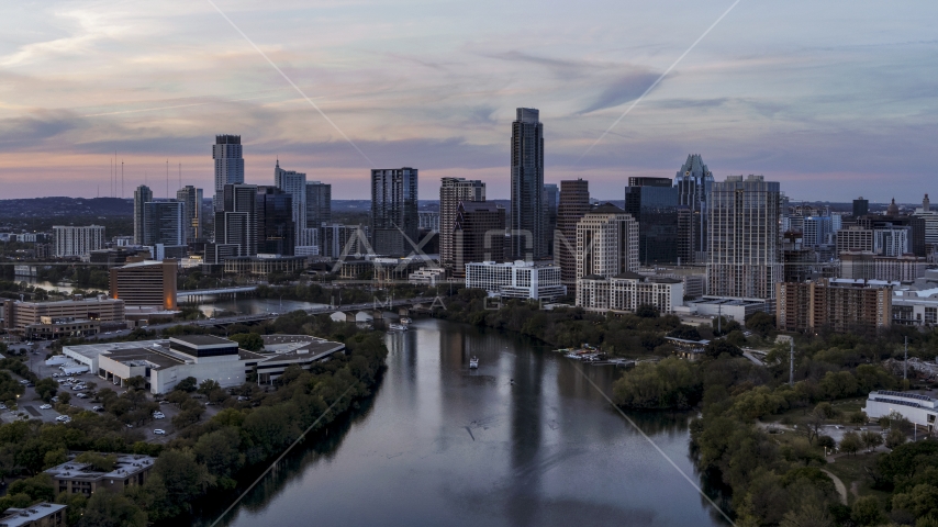 A view of of The Austonian and city skyline seen from Lady Bird Lake at twilight in Downtown Austin, Texas Aerial Stock Photo DXP002_110_0009 | Axiom Images