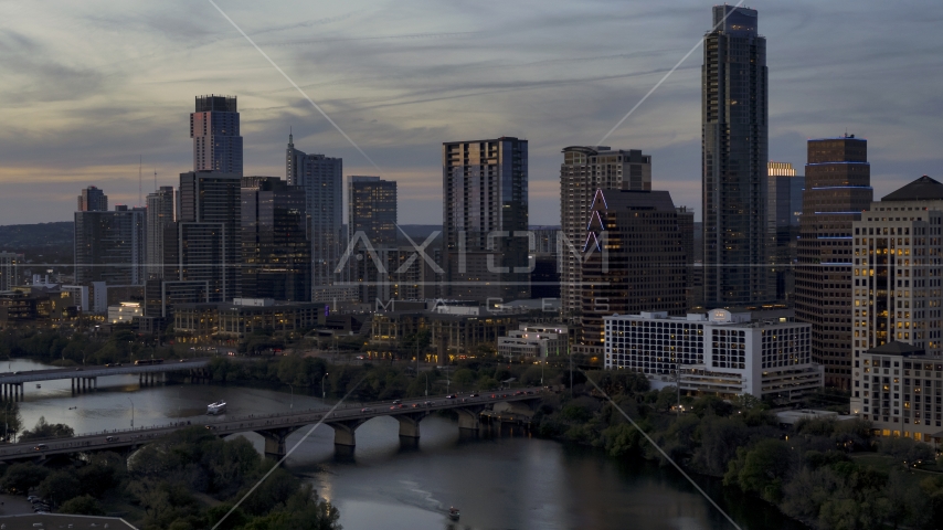 A bridge and skyscrapers beside Lady Bird Lake at twilight in Downtown Austin, Texas Aerial Stock Photo DXP002_110_0017 | Axiom Images