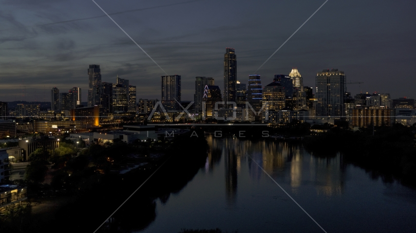 A view of Lady Bird Lake, focus on the waterfront skyline at twilight in Downtown Austin, Texas Aerial Stock Photo DXP002_111_0001 | Axiom Images