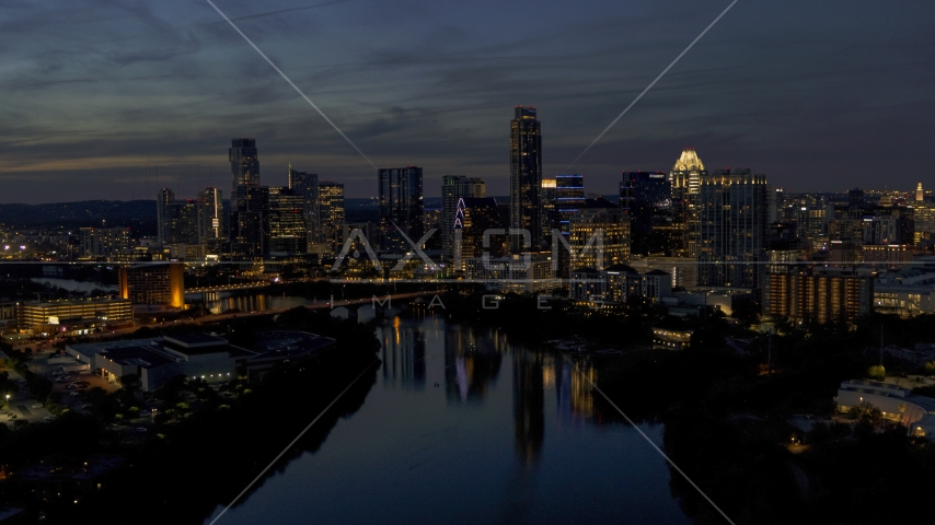 A view of Lady Bird Lake, focus on the waterfront skyline at twilight in Downtown Austin, Texas Aerial Stock Photo DXP002_111_0002 | Axiom Images