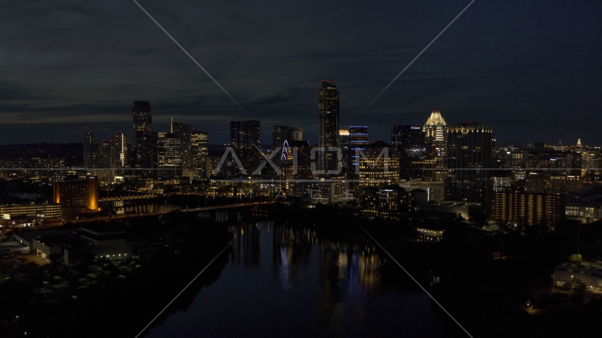 The waterfront skyline on the opposite shore of Lady Bird Lake at night in Downtown Austin, Texas Aerial Stock Photo DXP002_111_0005 | Axiom Images