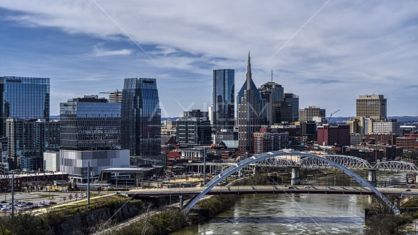 Office high-rise and skyscrapers seen from river and bridge in Downtown Nashville, Tennessee Aerial Stock Photo DXP002_116_0010 | Axiom Images