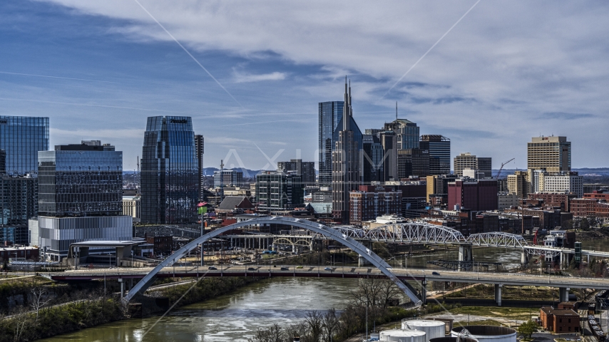 A river and bridge, skyscrapers in the background in Downtown Nashville, Tennessee Aerial Stock Photo DXP002_116_0011 | Axiom Images