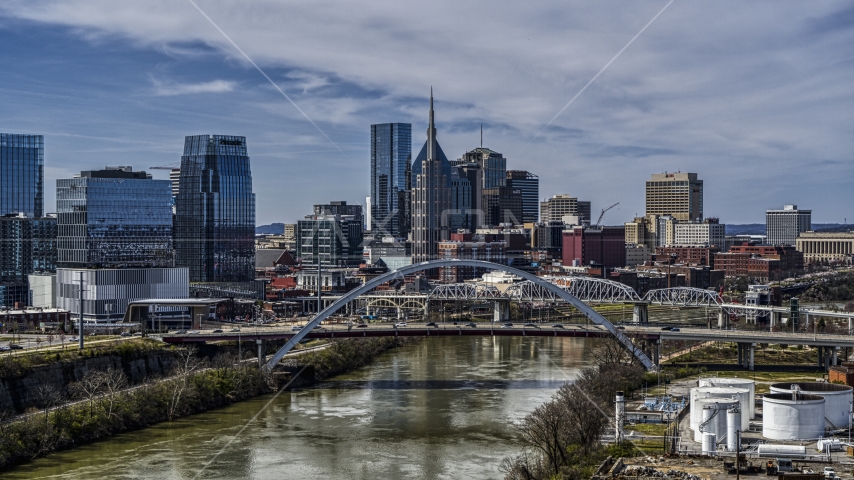 A bridge and the river while focused on city skyscrapers in Downtown Nashville, Tennessee Aerial Stock Photo DXP002_116_0015 | Axiom Images