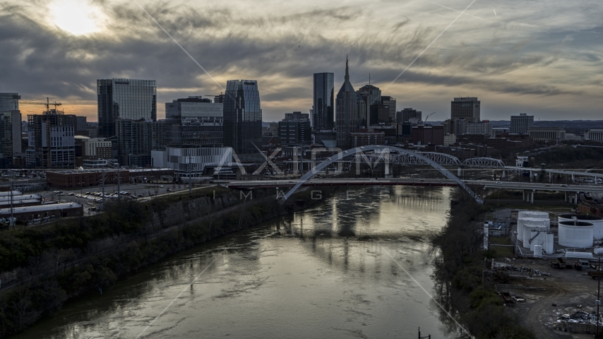 The city skyline behind a bridge on Cumberland River at sunset, Downtown Nashville, Tennessee Aerial Stock Photo DXP002_119_0009 | Axiom Images