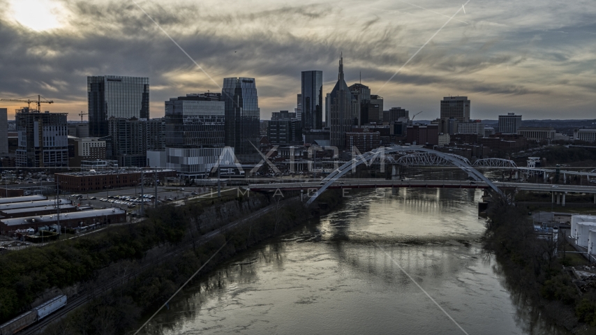 The city skyline behind a bridge on Cumberland River at sunset, Downtown Nashville, Tennessee Aerial Stock Photo DXP002_119_0010 | Axiom Images