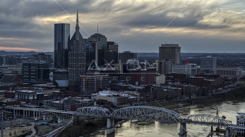 Riverfront skyline, pedestrian bridge, and Cumberland River at sunset, Downtown Nashville, Tennessee Aerial Stock Photo DXP002_120_0006 | Axiom Images