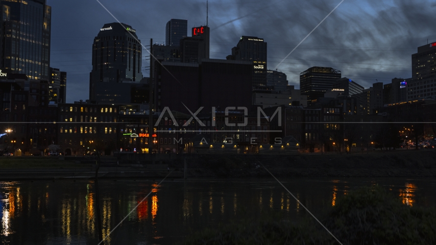 Skyscrapers at twilight seen from low over the river, Downtown Nashville, Tennessee Aerial Stock Photo DXP002_120_0020 | Axiom Images