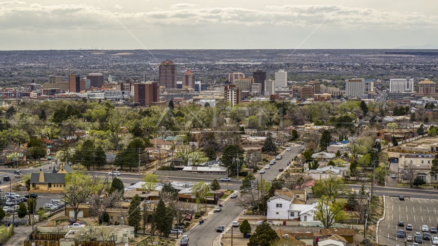 Wide view of city's high-rises seen while flying by homes, Downtown Albuquerque, New Mexico Aerial Stock Photo DXP002_126_0005 | Axiom Images