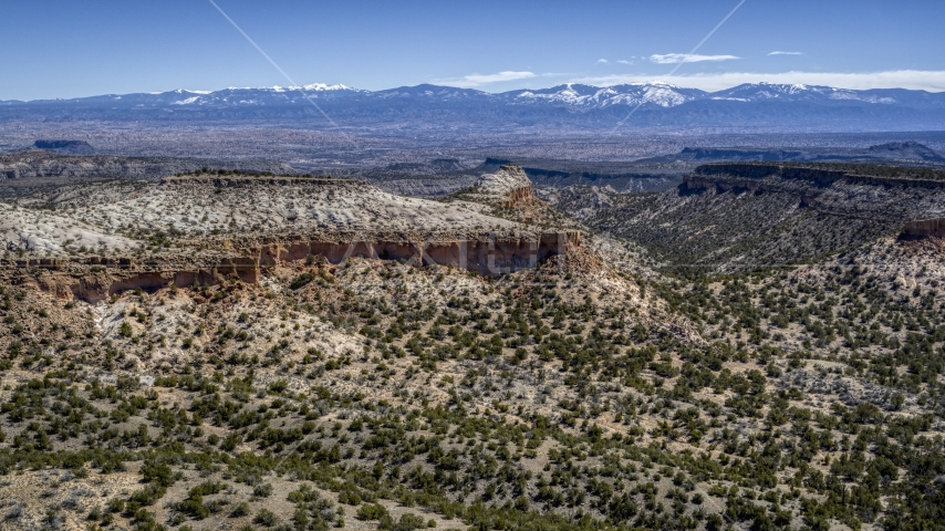 A wide view of desert mesas and distant mountains in New Mexico Aerial Stock Photo DXP002_133_0005 | Axiom Images