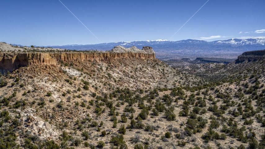 A desert mesa, mountains in distance, in New Mexico Aerial Stock Photo DXP002_133_0007 | Axiom Images