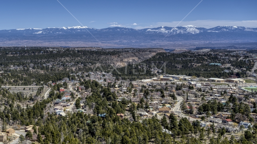 A view of distant mountains seen from homes near mesas and canyons in Los Alamos, New Mexico Aerial Stock Photo DXP002_134_0003 | Axiom Images