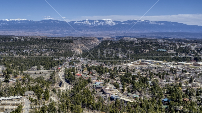 A wide view of distant mountains seen from homes near mesas and canyons in Los Alamos, New Mexico Aerial Stock Photo DXP002_134_0004 | Axiom Images
