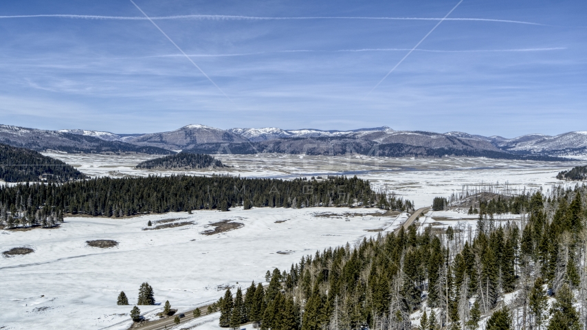 Distant mountains seen across a snowy valley, New Mexico Aerial Stock Photo DXP002_134_0007 | Axiom Images