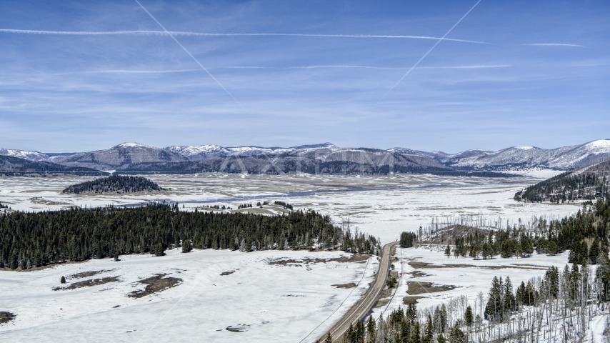 Wide view of distant mountains on the other side of a snow-covered valley, New Mexico Aerial Stock Photo DXP002_134_0009 | Axiom Images