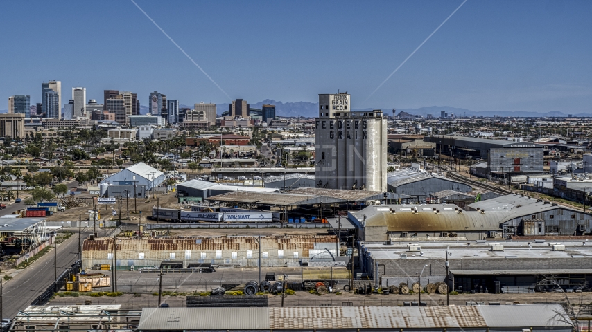 A grain elevator, with the skyline of  Downtown Phoenix, Arizona in the background Aerial Stock Photo DXP002_136_0009 | Axiom Images