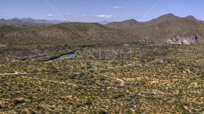 A desert road with light traffic, and mountains in the background Aerial Stock Photo DXP002_141_0021 | Axiom Images