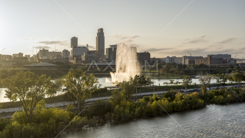A fountain and riverfront park with view of skyline at sunset, Downtown Omaha, Nebraska Aerial Stock Photo DXP002_172_0003 | Axiom Images